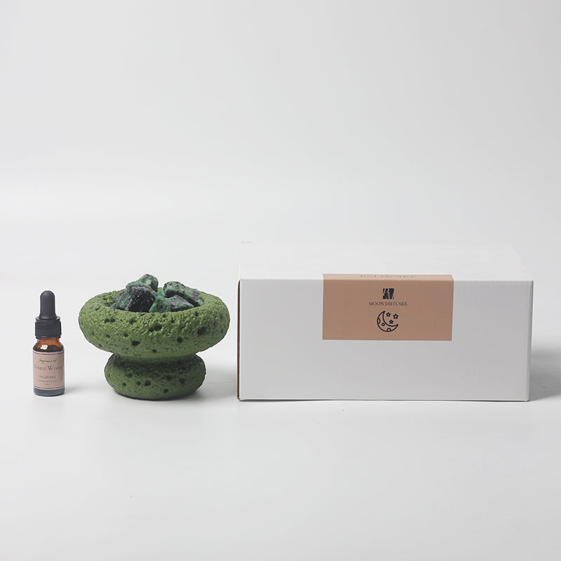 Green Moon Vessel diffuser with Forest Woods fragrance oil displayed next to minimalist branded packaging