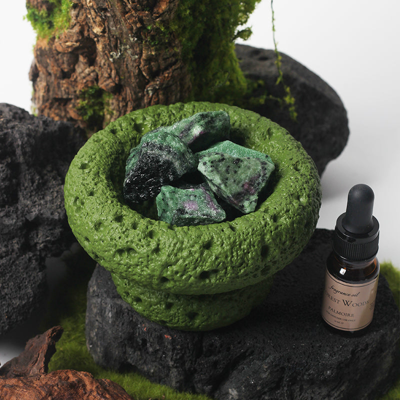 Green Moon Vessel diffuser with natural crystals displayed on stone with moss and Forest Woods fragrance oil
